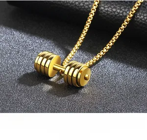 Dettaglio di una collana con ciondolo a manubrio in oro lucido su una texture in pelle nera