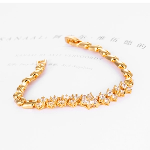 Détail d'un bracelet plaqué or avec motifs floraux et pierres en zircone étincelantes
