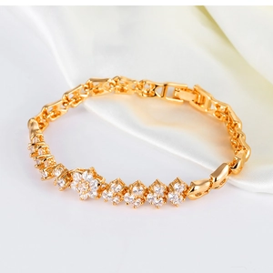 Détail d'un bracelet de mariée doré avec fleurs en zircon 3A et pierres carrées