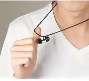 Dettaglio di una collana con ciondolo a manubrio nero in acciaio inossidabile su un modello uomo