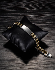 Detail of two-tone steel motorcycle chain bracelet with a polished engravable metal plate