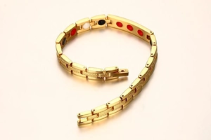 Detail of gold magnetic therapy bracelet featuring textured links and multi-color inserts