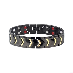 Dettaglio del bracciale magnetico nero con frecce a V dorate e magneti terapeutici