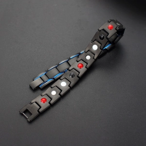 Detail of black magnetic titanium bracelet showing blue stripes and inlaid energy stones