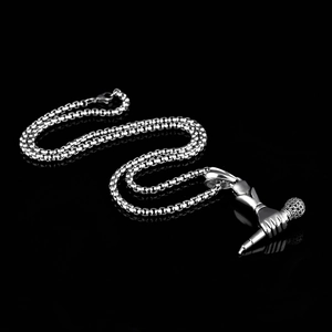 Collar hip hop con colgante de micrófono plateado sobre fondo negro con reflejo