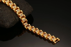 Detail of gold-plated link bracelet featuring blue gemstones and crystal flower accents