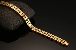 Macro shot of gold stainless steel magnetic bracelet with black stones and fold-over clasp