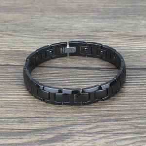 Men's magnetic black ceramic bracelet with polished links on a wooden surface
