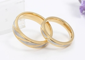 Macro shot of gold and silver diagonal brushed texture on titanium steel couple rings