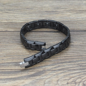 Detail of black ceramic magnetic link bracelet with folding clasp on wooden background