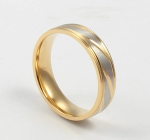 Close-up of gold and silver bicolor stainless steel ring with diagonal groove texture