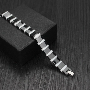 Close-up of black and white ceramic link bracelet with silver folding clasp for men