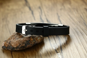 Détail du bracelet en silicone noir réglable avec boucle en métal argenté sur pierre