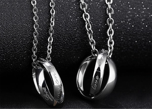 Macro view of interlocking heart pendants with Love engraving and polished finish