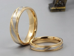 Detail view of gold and silver titanium steel ring with diagonal lines and brushed finish