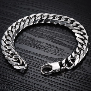 Gourmette homme en acier inoxydable avec boucle carrée sur fond de bois noir élégant