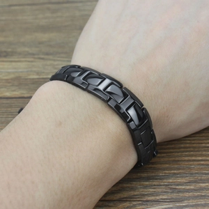 Close-up of polished black magnetic bracelet featuring modern H-shaped ceramic links