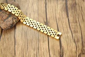 Vue détaillée du bracelet gourmette doré type montre avec fermoir pliant classique