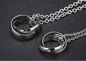 Macro shot of interlocking triple-ring heart necklace with polished steel and zircon