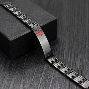 Macro shot of black stainless steel medical alert bracelet with red Star of Life symbol
