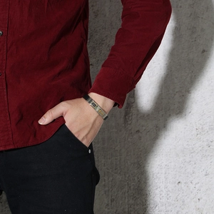 Détail d'un bracelet en silicone pour homme avec croix dorée porté sur le poignet d'un mannequin