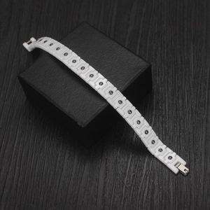 Bracelet magnétique en céramique blanche avec pierres noires sur un écrin à bijoux noir