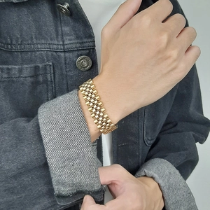 Détail d'un bracelet gourmette doré en acier inoxydable à maillons multiples au poignet