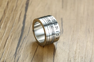Close-up of rotatable titanium steel ring featuring engraved numbers and industrial finish