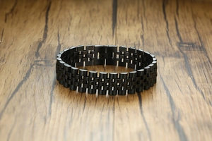 Détail d'un bracelet en acier inoxydable noir avec finition brossée et maillons de montre