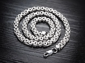 Détail du collier chaîne byzantine en argent avec fermoir mousqueton sur bois foncé