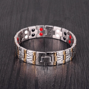 Detailed view of wide titanium magnetic bracelet with gold accents and energy stones