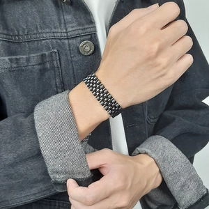 Détail d'un bracelet à maillons en acier inoxydable noir mat pour homme au poignet
