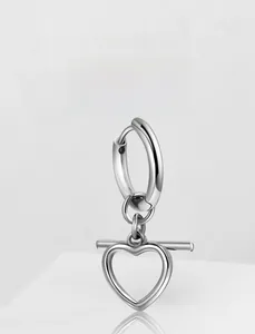 Detail showing a sleek stainless steel hoop earring with a heart-shaped pendant detail