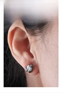 Close-up of crown-set zircon stud earring in vintage black steel on model's ear
