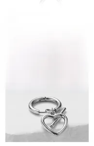 Detailed view of silver heart-shaped drop earrings in polished stainless steel