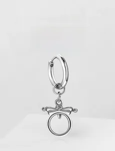 Détail de boucles d'oreilles en acier inoxydable avec pendentif nœud sur fond blanc