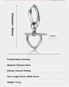 Macro shot of silver titanium steel earrings featuring a hollow heart-shaped pendant