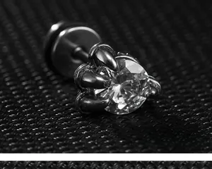 Macro shot of punk style dragon claw stud earring with a large clear cubic zirconia stone