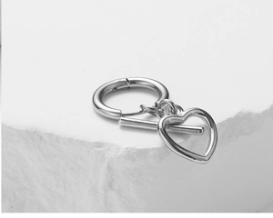 Detailed view of silver polished heart pendant with toggle clasp on stone surface