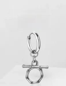 Macro detail of silver stainless steel bamboo style hoop earrings with T-bar pendant