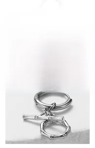 Detail of silver stainless steel hoop earrings with minimalist bamboo tube pendant design