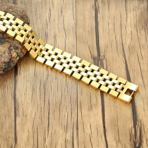 Bracelet de montre classique en acier inoxydable doré sur pierre et fond en bois