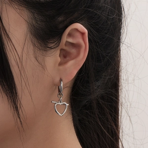 Minimalist silver stainless steel heart earrings with T-bar design on female model
