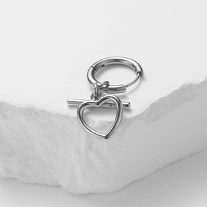 Minimalist silver stainless steel heart hoop earring displayed on a white rock base