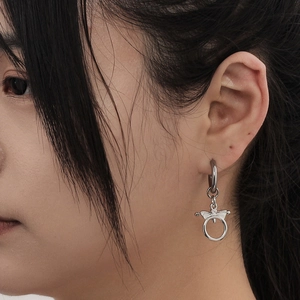 Boucles d'oreilles créoles punk en acier inoxydable avec pendentif aile sur le mannequin