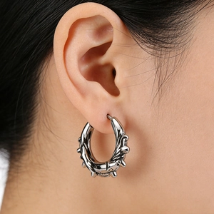 Macro shot of punk style stainless steel hoop earring with sharp textured spikes