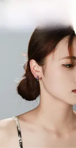 Detail view of a vintage V-shaped stainless steel earring with textured feather patterns
