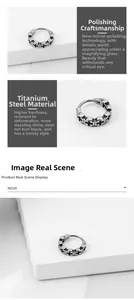 Close-up of titanium steel hoop earring with engraved black cross and mirror polish