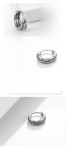 Detailed macro view of polished titanium steel hoop earring with feather texture carving