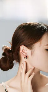 Gros plan d'un ear cuff minimaliste en acier titane noir en forme de U sur un mannequin